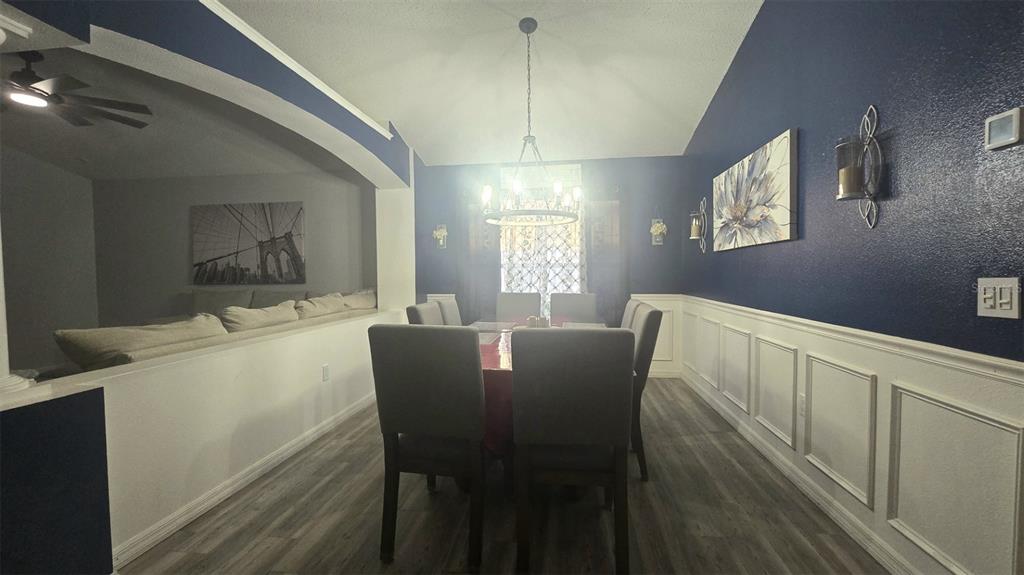 A dining room features a dark blue accent wall, white wainscoting, and a chandelier — 3220 ABIAKA DRIVE, KISSIMMEE, FL