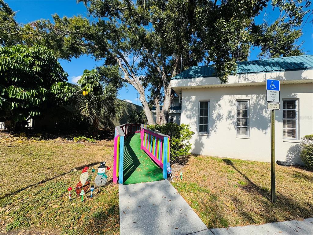 A colorful ramp leads to the entrance of a building with a handicap parking sign — 4509 BEE RIDGE ROAD UNIT E, SARASOTA, FL