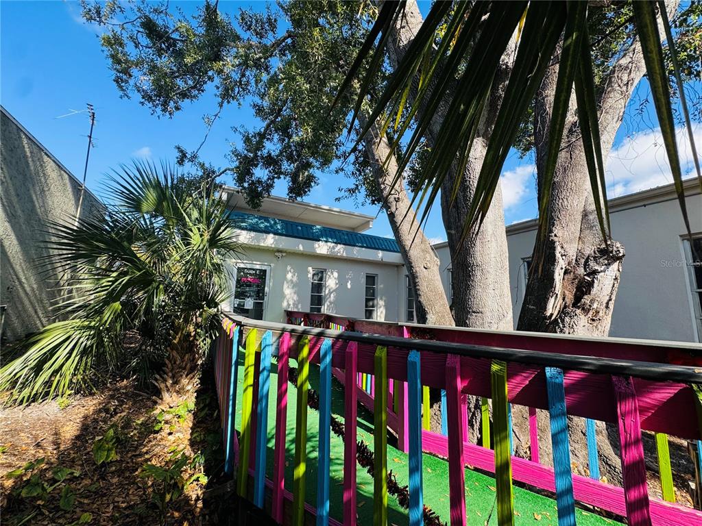 A brightly painted wooden ramp leads to the entrance of a commercial building suite — 4509 BEE RIDGE ROAD UNIT E, SARASOTA, FL