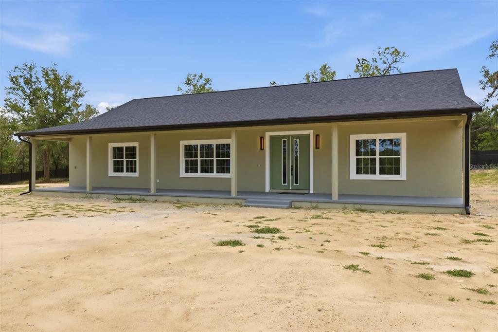 A single-story house with a green exterior, a covered front porch, and a dark roof — 5970 W INLAND, DUNNELLON, FL