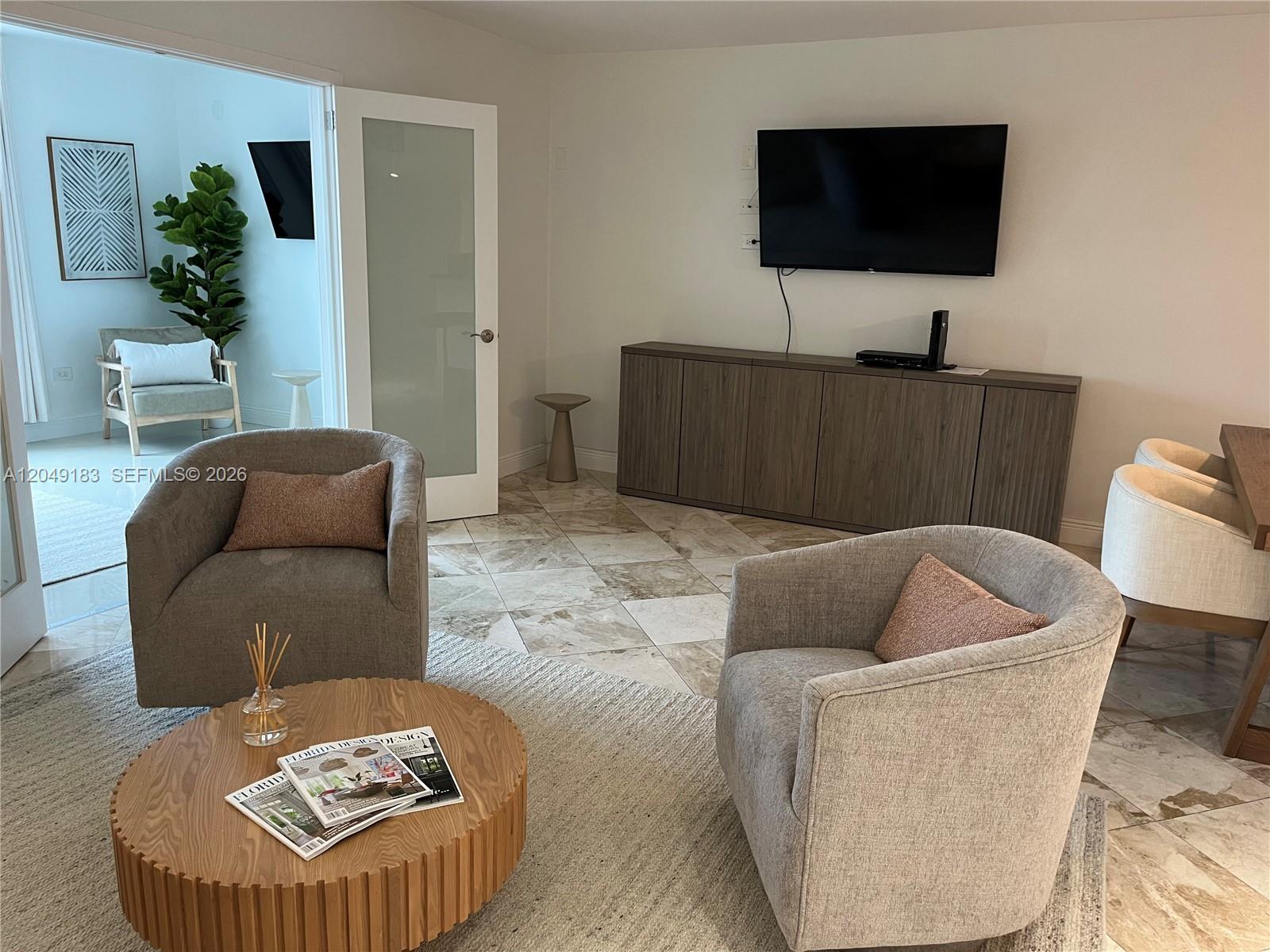 A living room features two gray armchairs, a round wooden coffee table, and a media console — 2301 Collins Ave # 731, Miami Beach FL 33139, MIAMI BEACH, FL