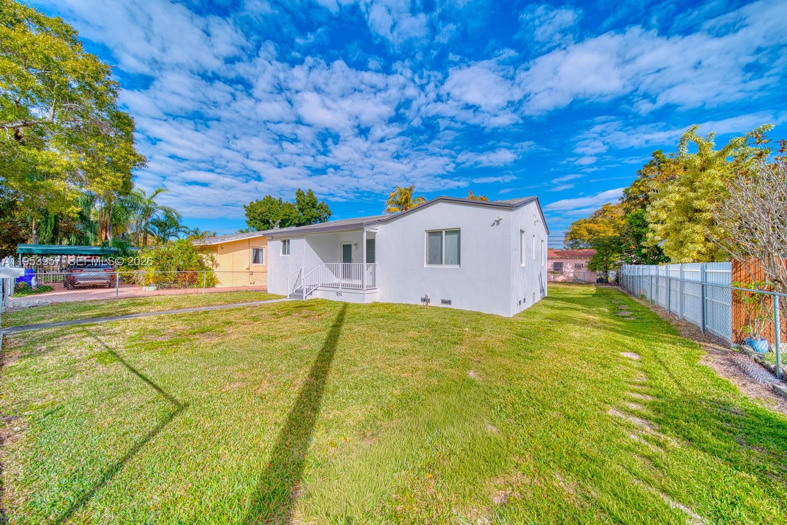 A white single-story house with a fenced backyard under a blue sky — 4345 SW 5th Ter, Miami FL 33134, MIAMI, FL