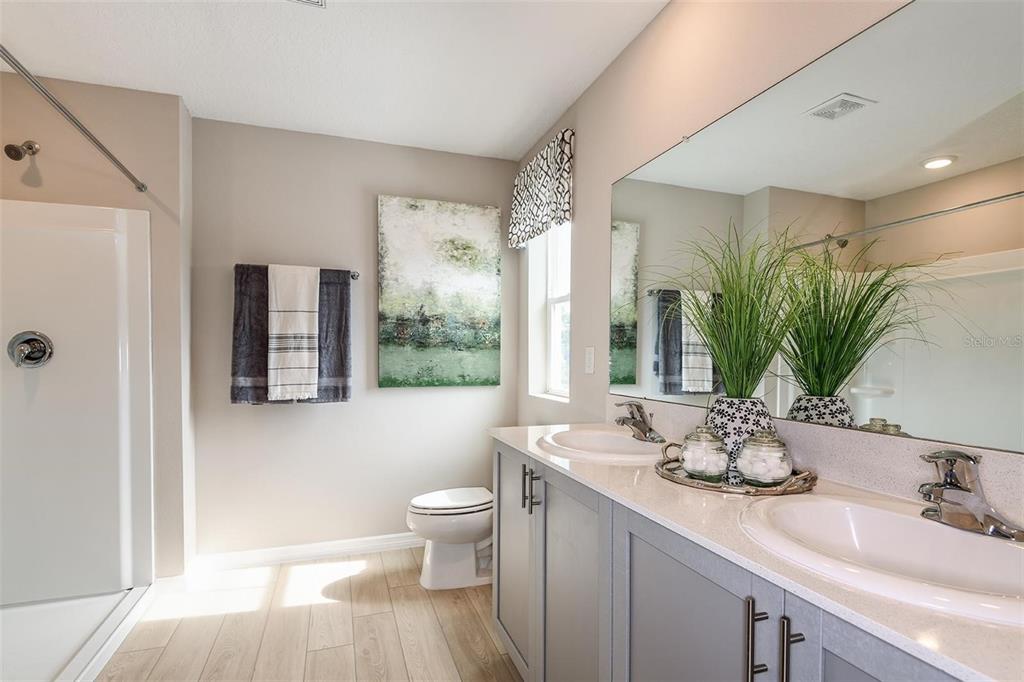 A bathroom features a double vanity with gray cabinets, a walk-in shower, and tile flooring — 36645 SAGEMOOR DRIVE, ZEPHYRHILLS, FL