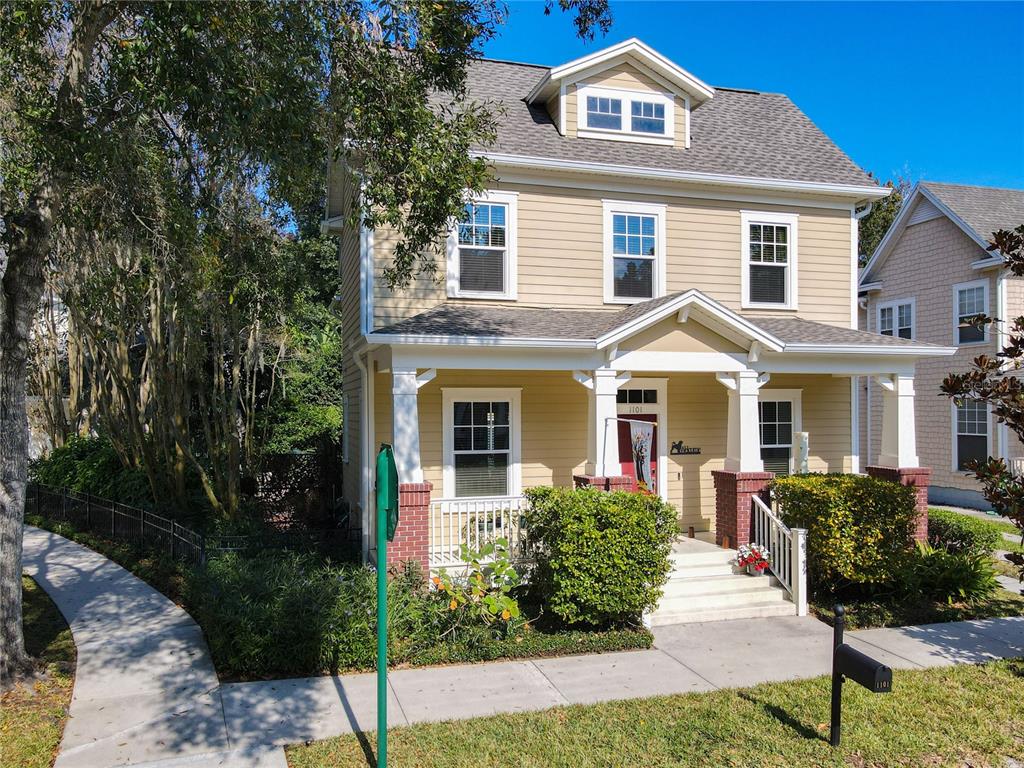 A two-story tan house with a front porch, dormer window, and a sidewalk — 1101 BANKS ROSE COURT, CELEBRATION, FL