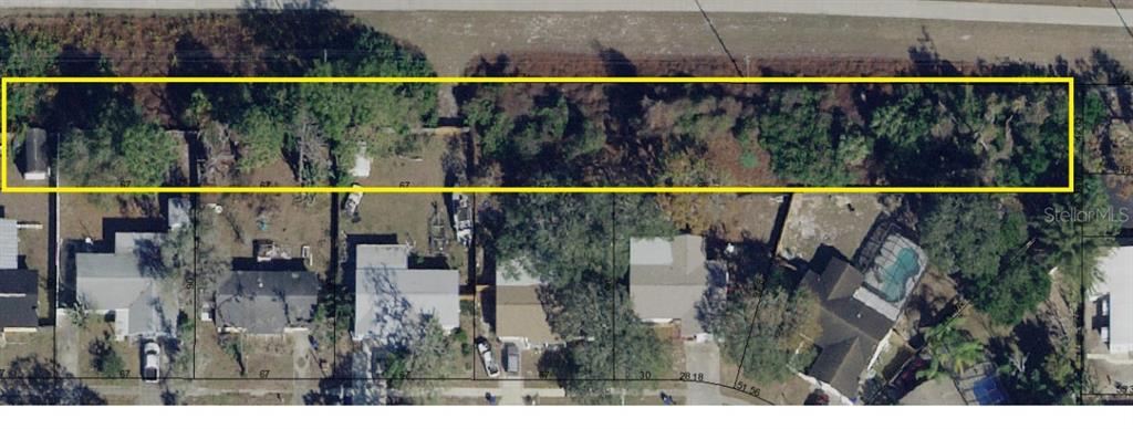 An aerial view shows a long, rectangular plot of land highlighted in yellow behind houses — LECANTO STREET, HOLIDAY, FL