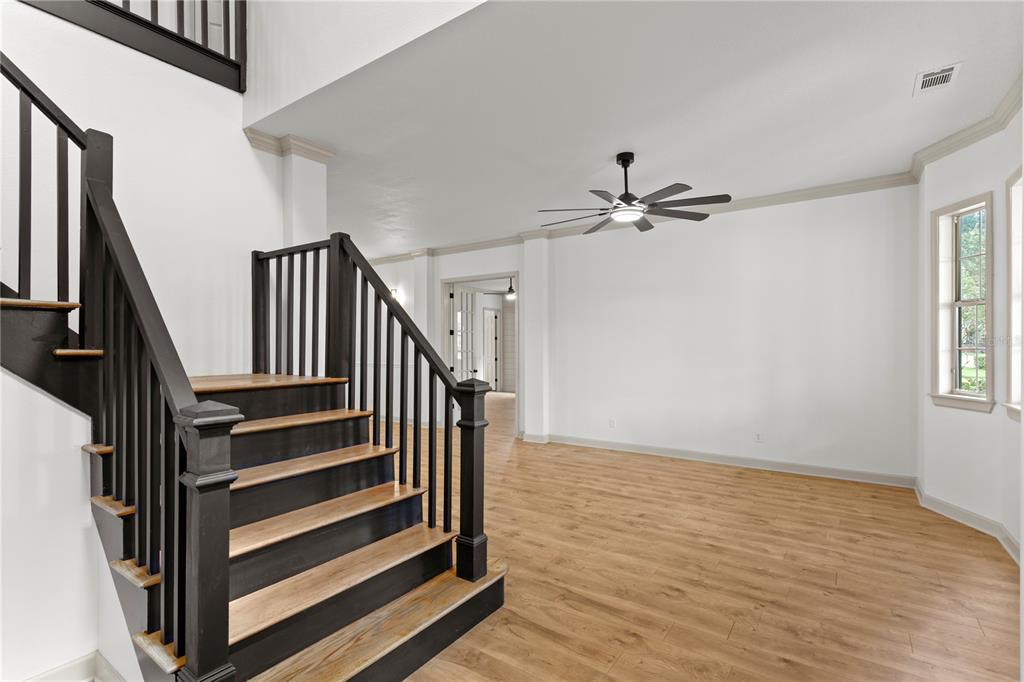 A staircase with dark railings and wood treads leads to an open living area — 8807 EAGLE WATCH DRIVE, RIVERVIEW, FL