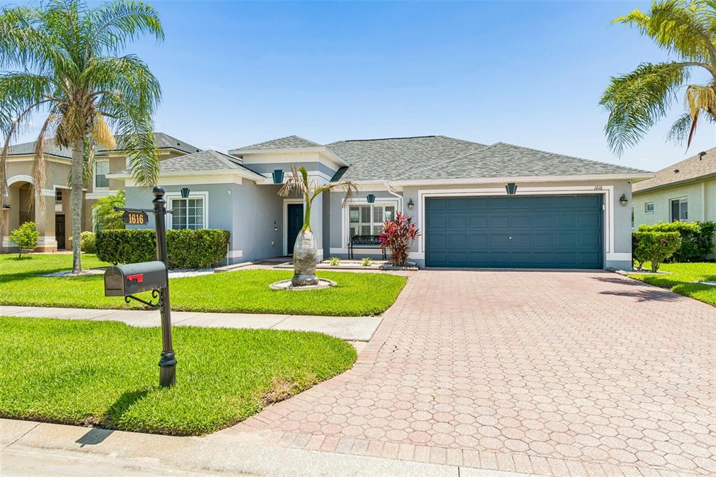 A single-story house with a gray exterior, a paved driveway, and a two-car garage — 1616 REGAL MIST LOOP, TRINITY, FL