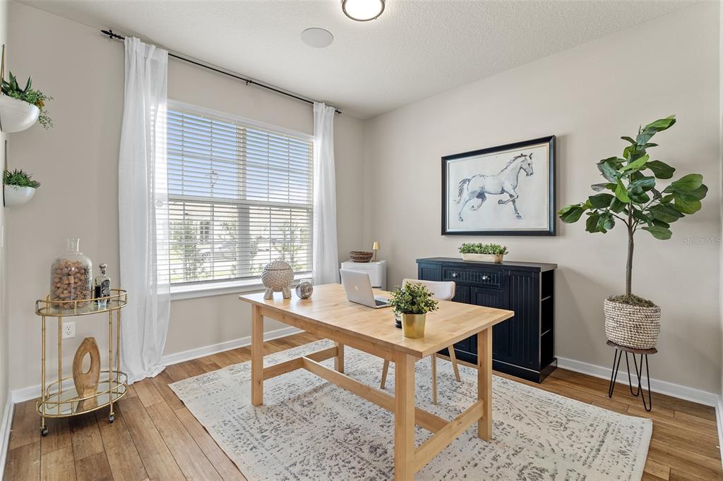 A home office features a wooden desk, a black sideboard, and a large window — 1444 GRAND PALM DRIVE, ORLANDO, FL