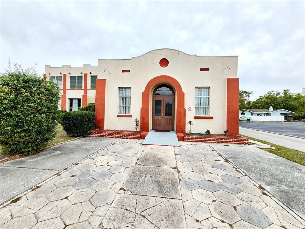 A Spanish-style building features a central arched entrance, stucco walls, and a stone-paved walkway — 1315 9TH AVENUE N, ST PETERSBURG, FL