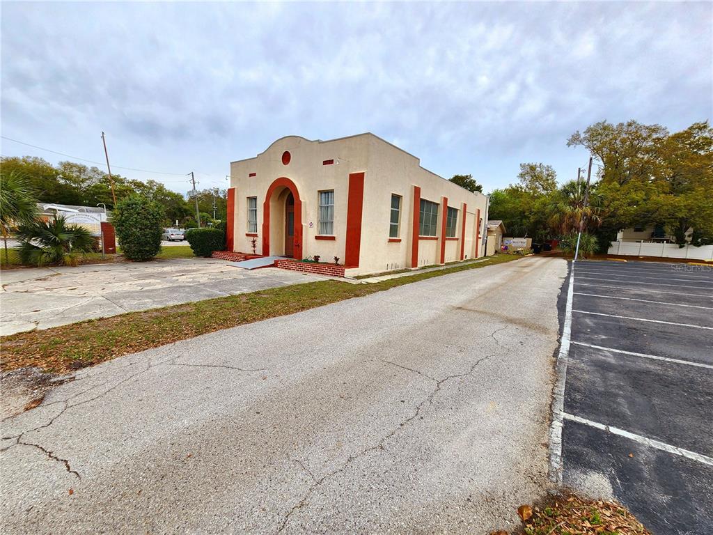 A tan building with a white door and a small garden area in front — 1315 9TH AVENUE N, ST PETERSBURG, FL