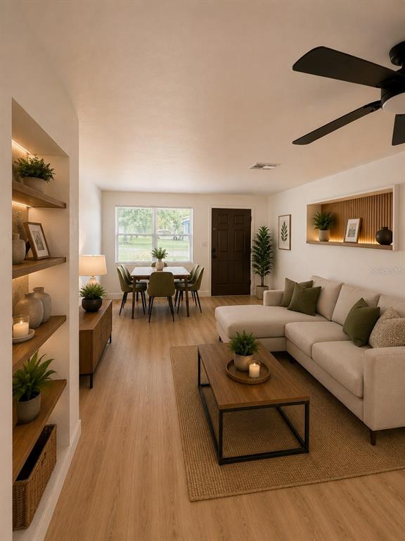 A living room and dining area feature light wood flooring, a sectional sofa, and shelving — 800 MARY STREET, EDGEWATER, FL