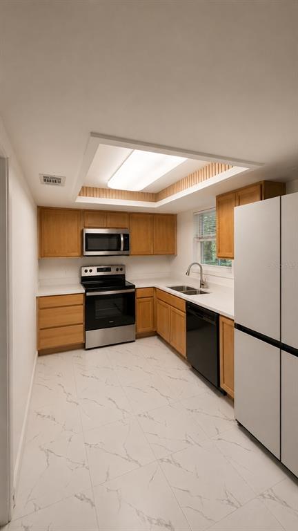 A kitchen with wood cabinets, stainless steel appliances, and white marble-patterned tile flooring — 800 MARY STREET, EDGEWATER, FL