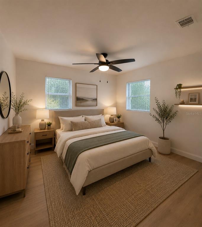 A bedroom features a bed with a green runner, two nightstands, and a ceiling fan — 800 MARY STREET, EDGEWATER, FL