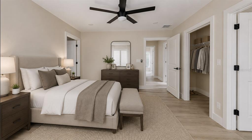 A bedroom with a bed, dresser, ceiling fan, and walk-in closet with light wood flooring — 5112 3RD AVENUE N, ST PETERSBURG, FL