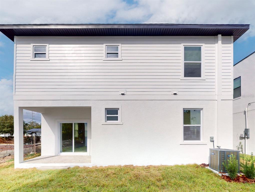 The exterior of a two-story white house features horizontal siding, a patio, and an AC unit — 5112 3RD AVENUE N, ST PETERSBURG, FL