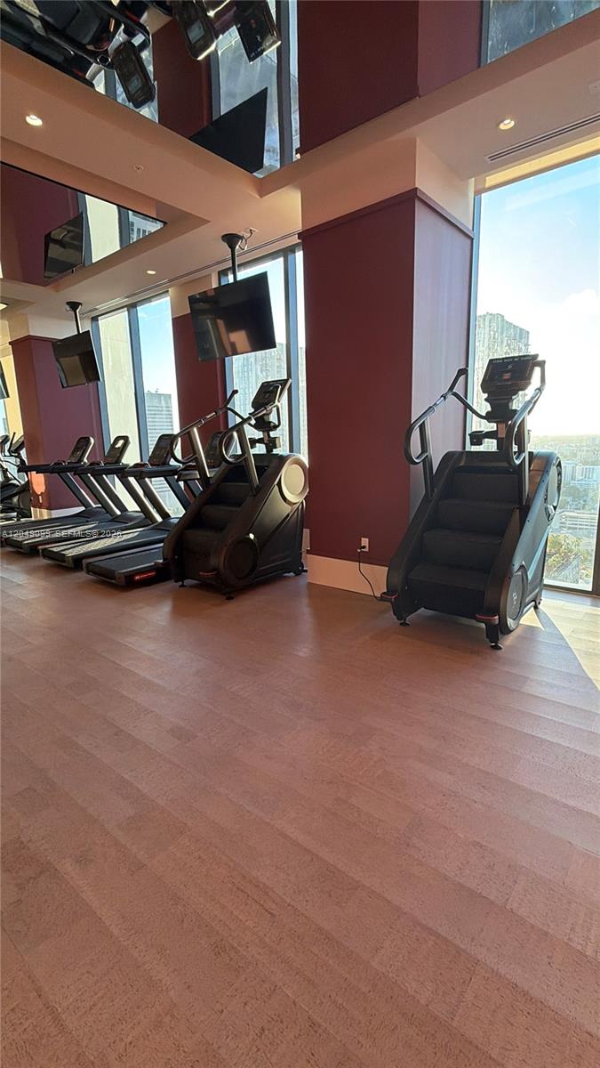 A gym room features several treadmills and stair climbers positioned in front of large windows — 11 NE 6th St # 515, Miami FL 33132, MIAMI, FL