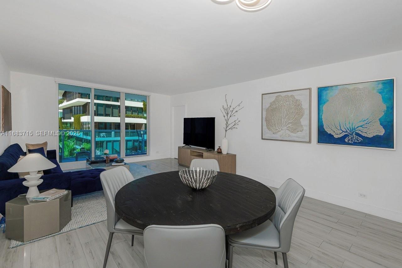 A dining area with a round table and chairs sits adjacent to a living room — 2301 Collins Ave # 534, Miami Beach FL 33139, MIAMI BEACH, FL