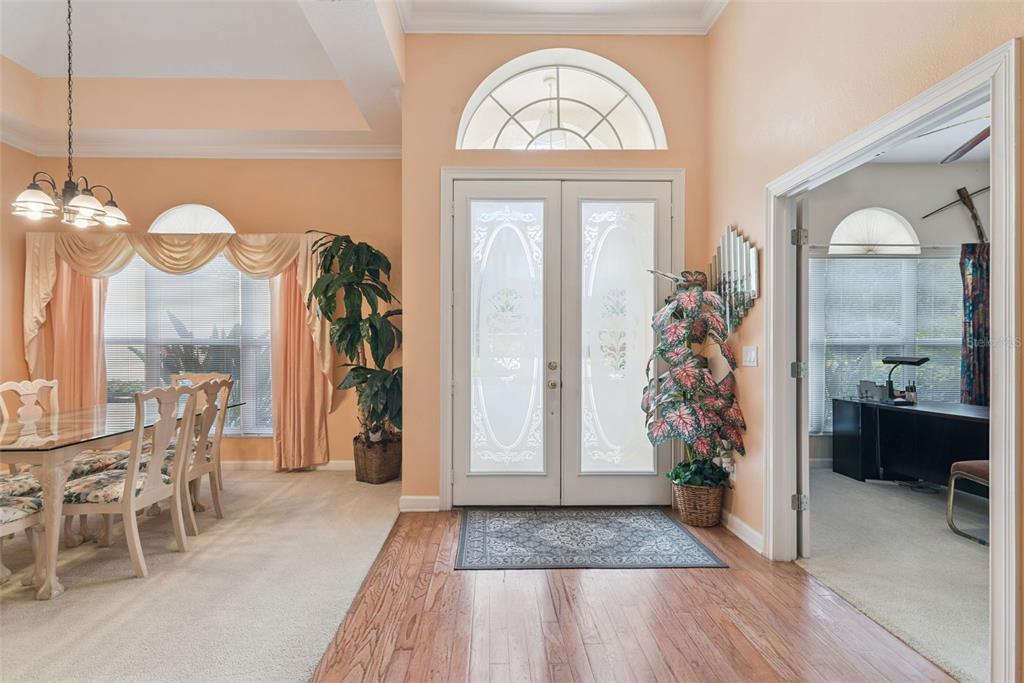 An entryway features double glass doors, hardwood flooring, and an adjacent dining area — 126 SEVILLE CHASE DRIVE, WINTER SPRINGS, FL