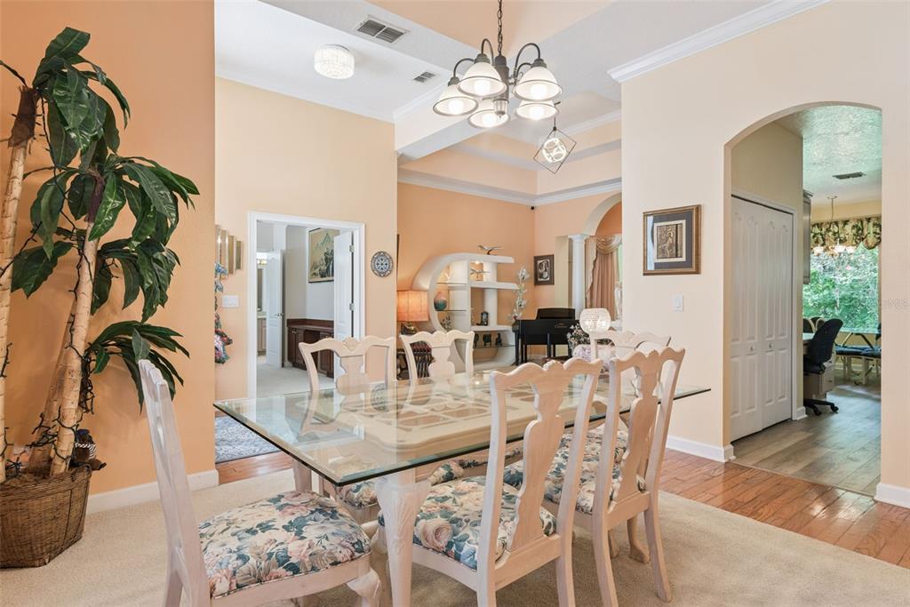 A dining room features a glass-topped table with floral chairs under a chandelier — 126 SEVILLE CHASE DRIVE, WINTER SPRINGS, FL