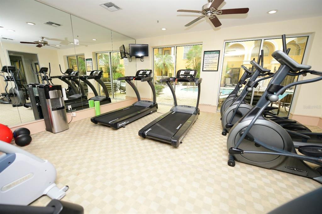 A fitness center features two treadmills, several elliptical machines, a water cooler, and mirrored walls — 860 N ORANGE AVENUE UNIT 213, ORLANDO, FL
