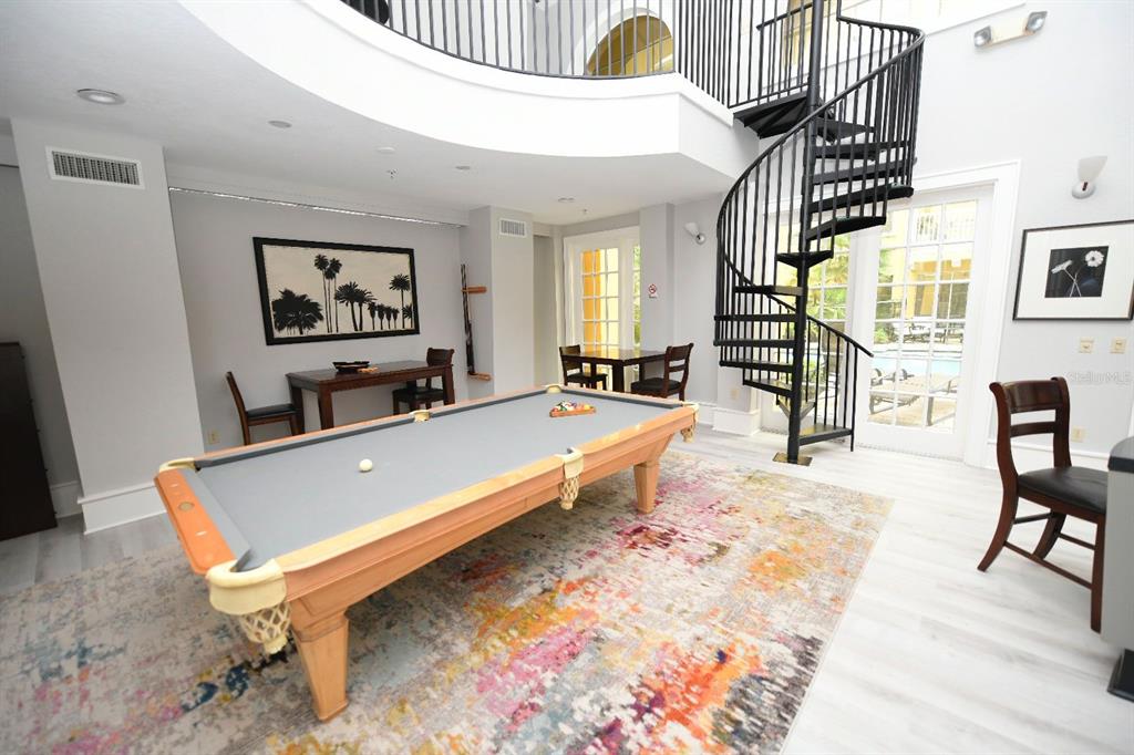 A game room features a pool table, a spiral staircase, and a colorful area rug — 860 N ORANGE AVENUE UNIT 213, ORLANDO, FL
