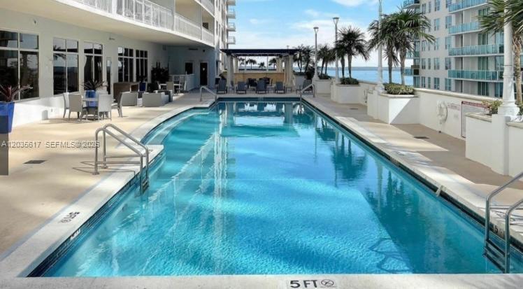 A rectangular swimming pool sits on a patio next to a multi-story residential building — 1200 Brickell Bay Dr # 3318, Miami FL 33131, MIAMI, FL