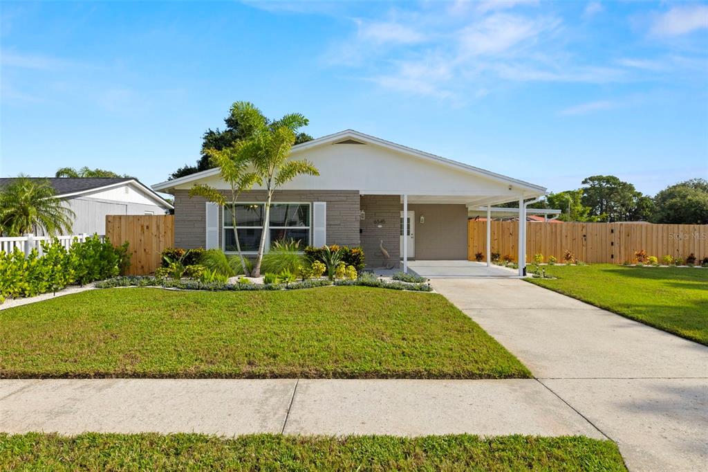 A single-story house with a gray brick facade, a white roof, and a concrete driveway — 6545 S WEST SHORE CIRCLE, TAMPA, FL