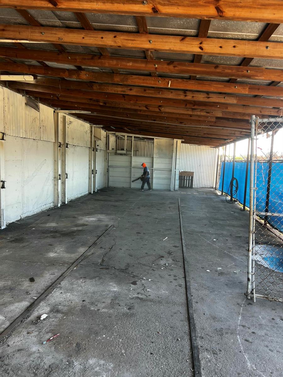 An open-air concrete storage area features a wooden roof structure and a chain-link fence — 17250 SW Railroad Avenue, FL 34956, FL