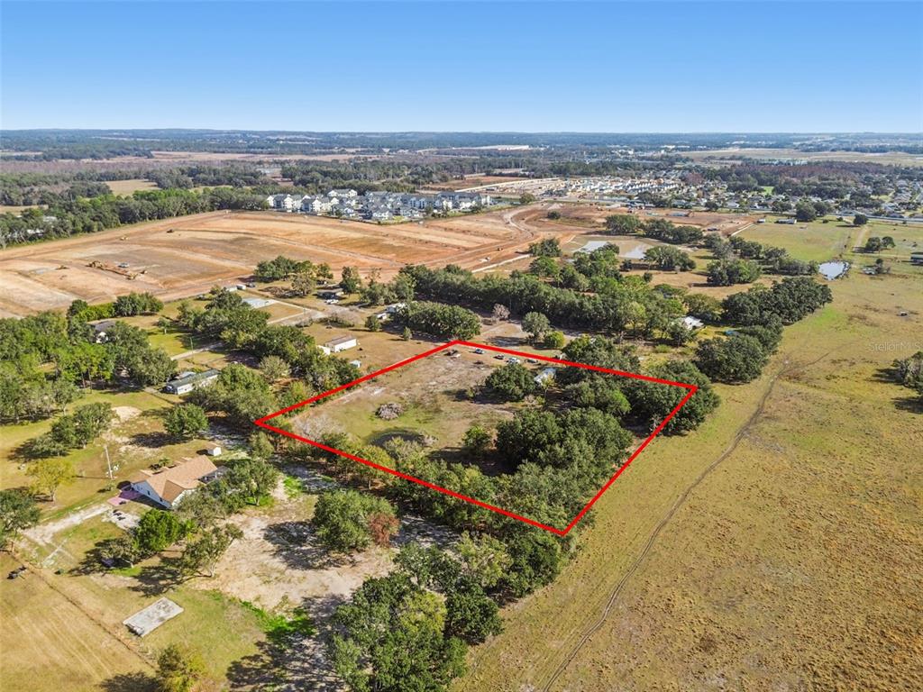 An aerial view shows a rectangular plot of land outlined in red amidst rural terrain — 28538 RICE ROAD, SAN ANTONIO, FL