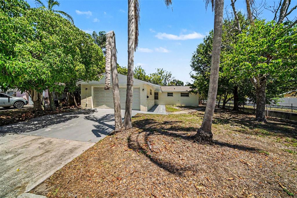 A single-story house with a two-car garage and palm trees in the front yard — 5301 82ND AVENUE N, PINELLAS PARK, FL