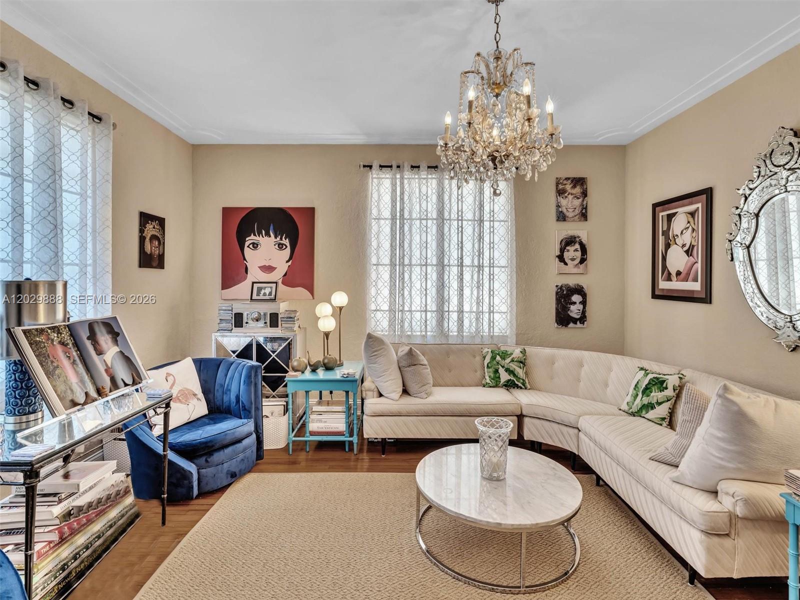 A living room features a curved white sofa, a blue armchair, and a crystal chandelier — 928 Euclid Ave # 2, Miami Beach FL 33139, MIAMI BEACH, FL