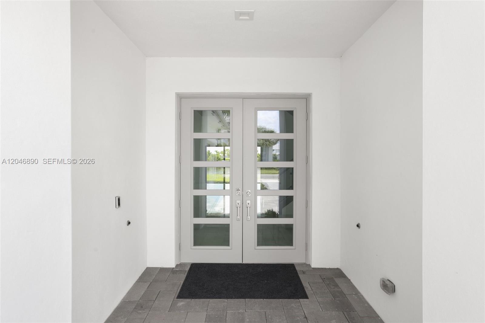 A gray double door with glass panels serves as the entrance to a white-walled foyer — 12866 Crane Xing, Palm Beach Gardens FL 33412, PALM BEACH GARDENS, FL