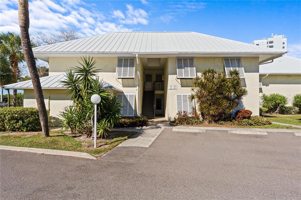 A two-story residential building with a metal roof, white shutters, and a central staircase — 7310 SUNSHINE SKYWAY LANE S UNIT 112, ST PETERSBURG, FL