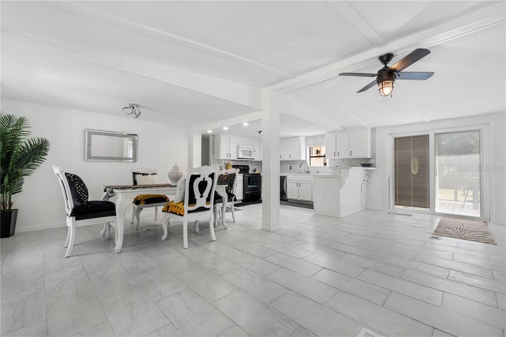 A dining area and kitchen with white cabinetry, tile flooring, and a ceiling fan — 8356 W TAWNY ROSE LANE, CRYSTAL RIVER, FL