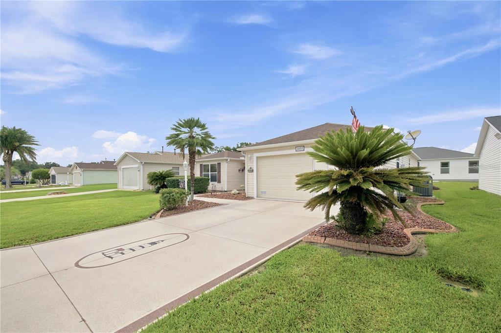 A single-story house with a concrete driveway, a palm tree, and a grassy front yard — 3455 SIPSEY STREET, THE VILLAGES, FL