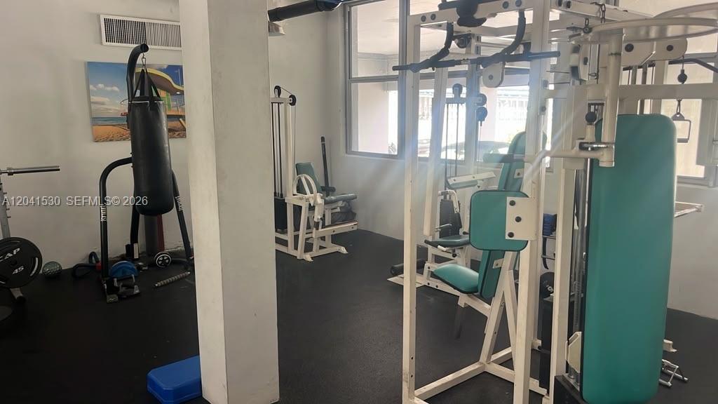 A gym room features a punching bag, weight machines, and a black rubber floor — 2016 Bay Dr # 602, Miami Beach FL 33141, MIAMI BEACH, FL