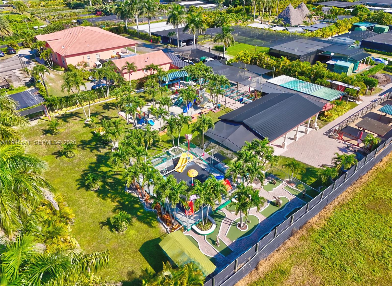 An aerial view shows a residential property featuring a playground and a miniature golf course — 20455 SW 154th Ave, Miami FL 33187, MIAMI, FL