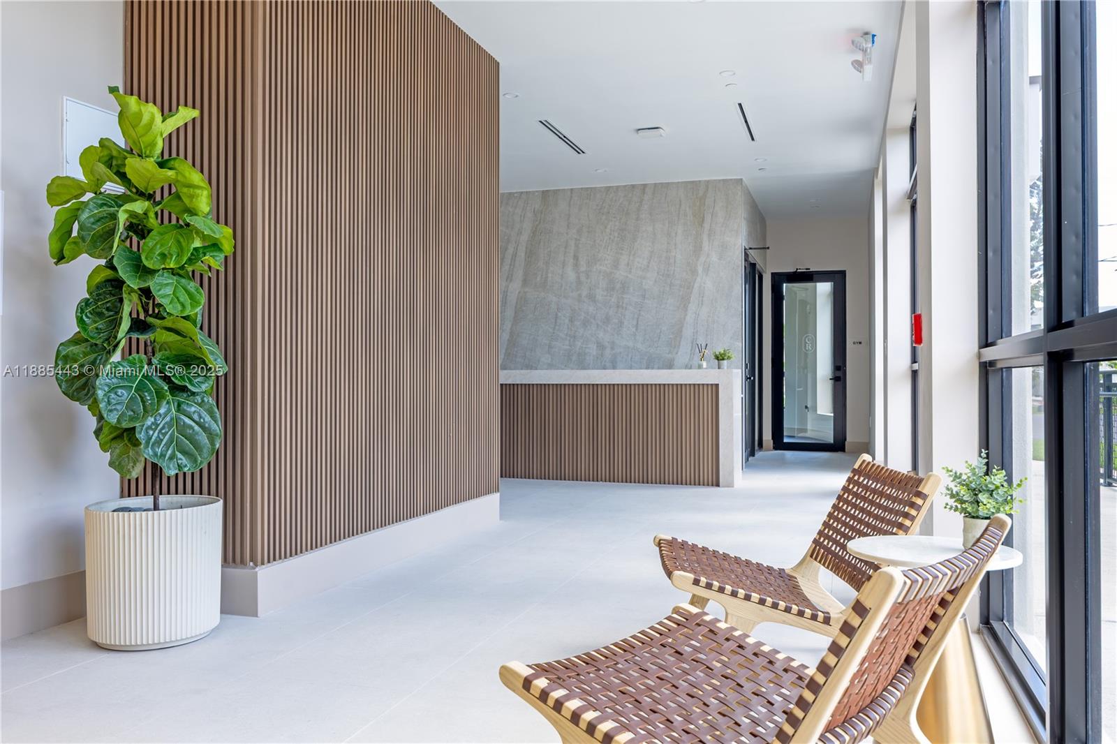 A modern lobby features slatted wood walls, a stone reception desk, and two woven chairs — 21850 Old Dixie highway # 001, Miami FL 33170, MIAMI, FL