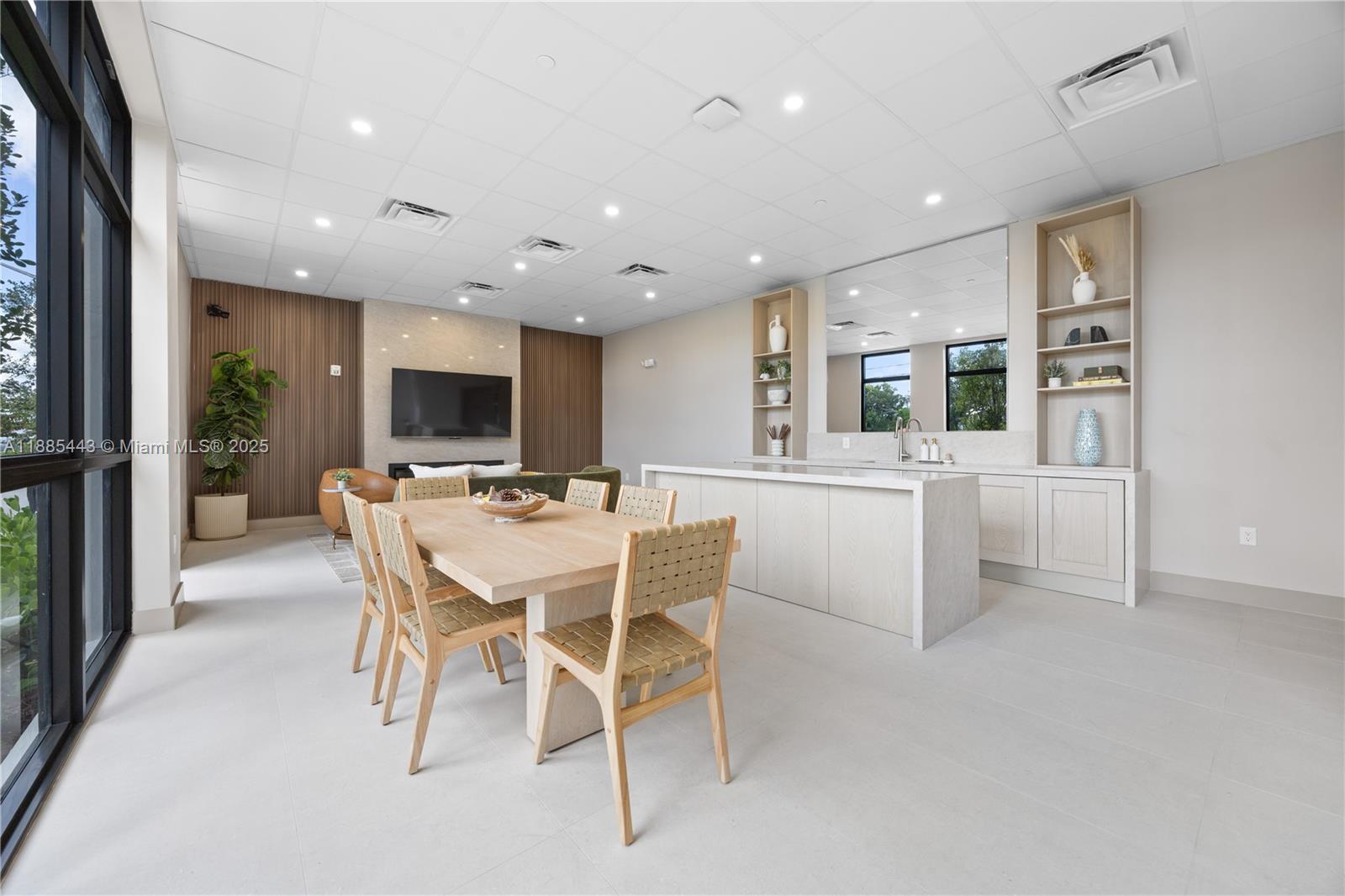 A modern dining area features a light wood table, woven chairs, and an adjacent kitchen — 21850 Old Dixie highway # 001, Miami FL 33170, MIAMI, FL
