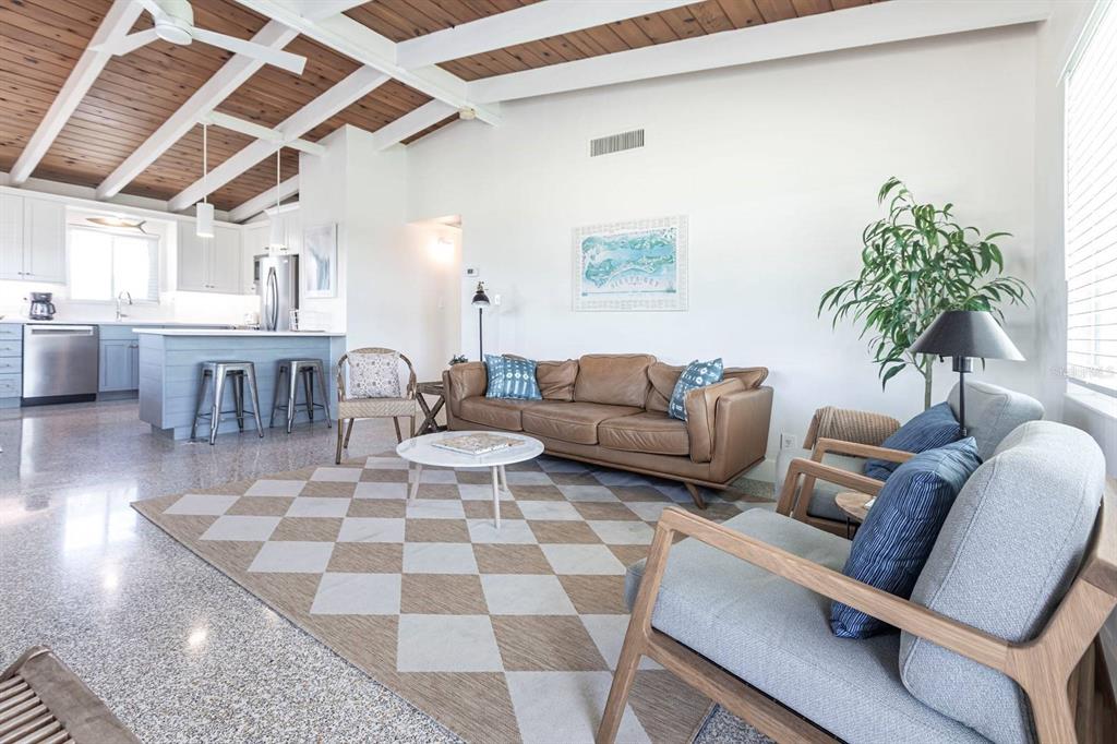 A living room with a brown leather sofa, patterned rug, and open kitchen with island — 6006 MIDNIGHT PASS ROAD UNIT 58, SARASOTA, FL