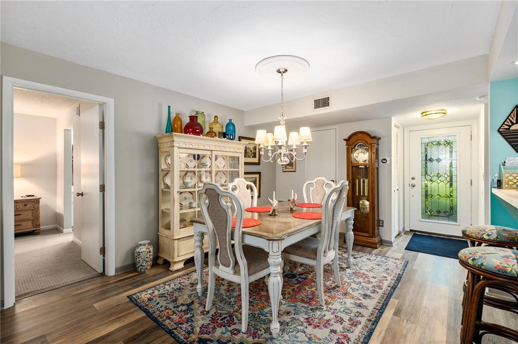 A dining room features a wooden table, chairs, a china cabinet, and a grandfather clock — 1701 PELICAN COVE ROAD UNIT 359, SARASOTA, FL