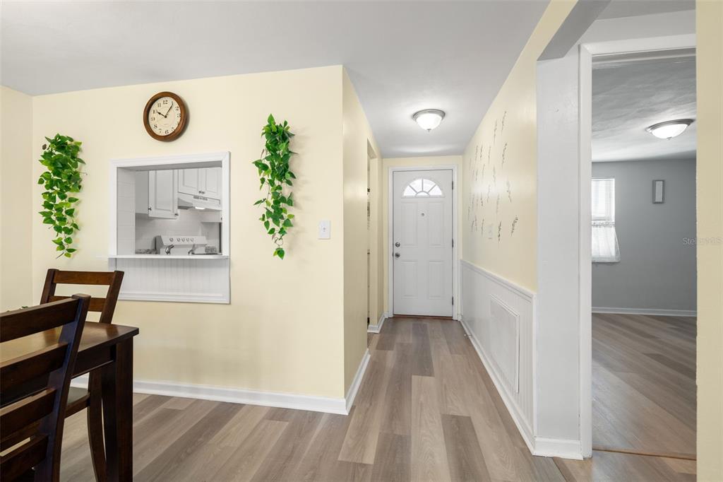 A dining area with a pass-through window leads to an entryway with a front door — 4239 TAMARGO DRIVE, NEW PORT RICHEY, FL