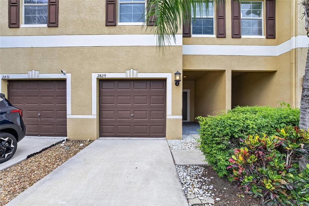 The exterior of a two-story townhouse features brown garage doors and a small front entryway — 2829 SANTEGO BAY COURT, BRANDON, FL