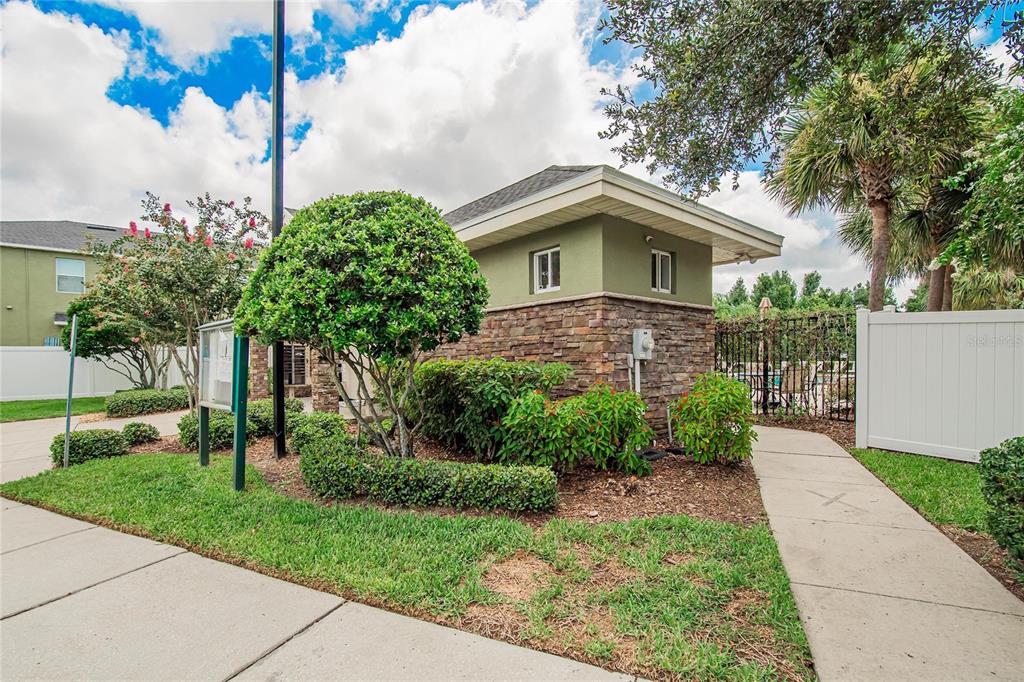 A small stone and green stucco building sits next to a sidewalk and landscaping — 2829 SANTEGO BAY COURT, BRANDON, FL