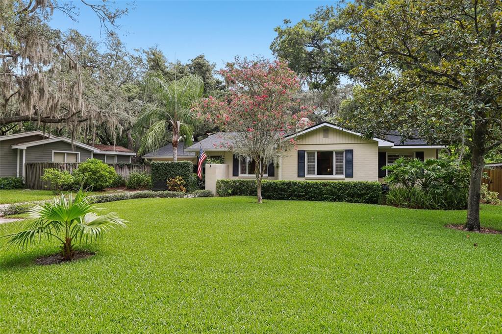 A single-story house with a beige exterior, dark shutters, and a large front lawn — 204 S BURLINGAME AVENUE, TEMPLE TERRACE, FL