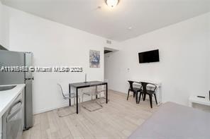 A small studio apartment features a kitchenette, a dining table, and a wall-mounted television — 820 15th St # 104, Miami Beach FL 33139, MIAMI BEACH, FL