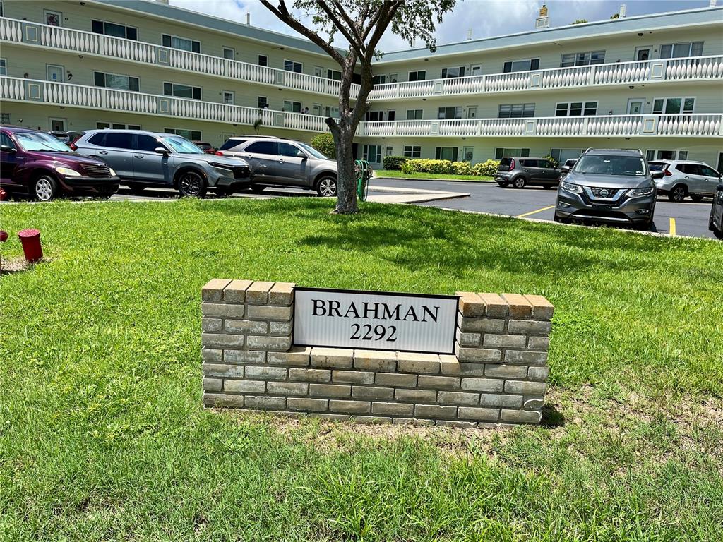 A brick sign for Brahman 2292 sits on a lawn in front of an apartment building — 2292 COSTA RICAN DRIVE UNIT 22, CLEARWATER, FL