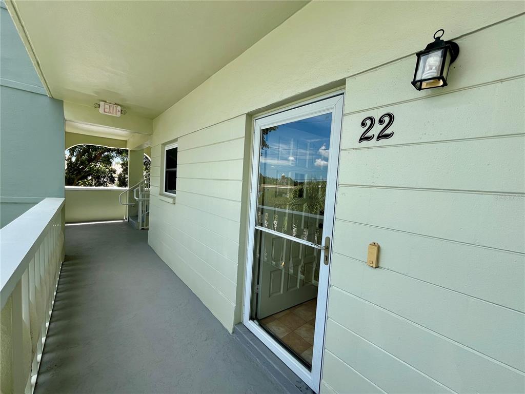 An exterior walkway leads to the entrance of a unit marked with the number 22 — 2292 COSTA RICAN DRIVE UNIT 22, CLEARWATER, FL