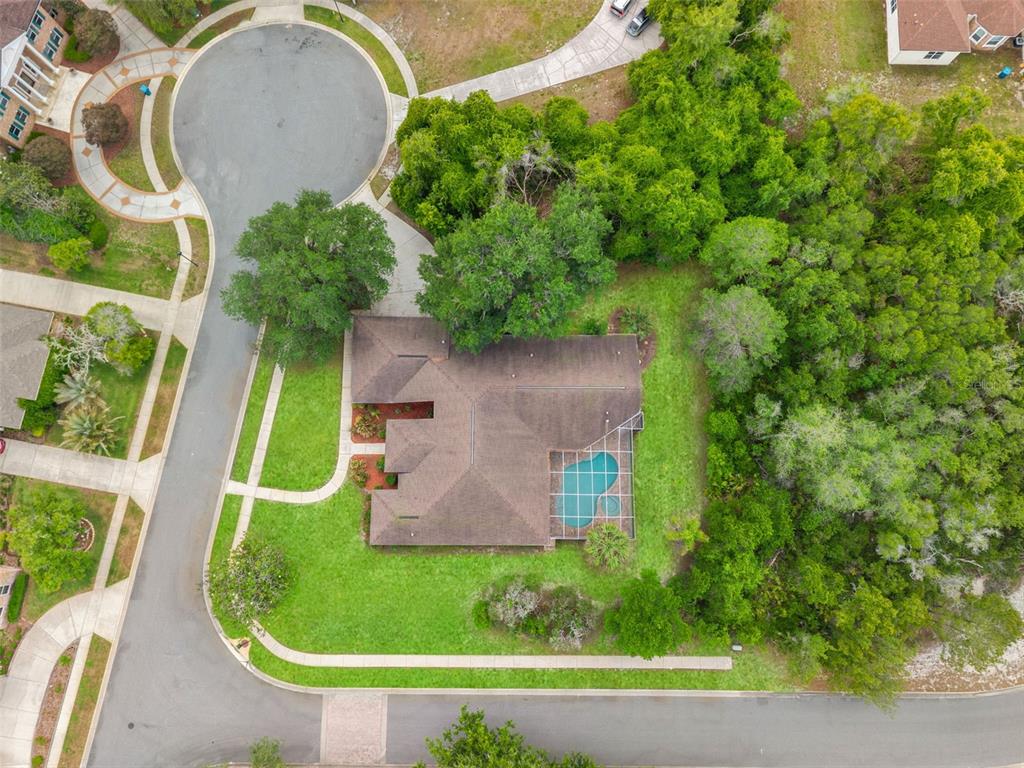 An aerial view shows a house with a screened pool situated on a corner lot — 6153 NEW OSPREY POINT, WEEKI WACHEE, FL