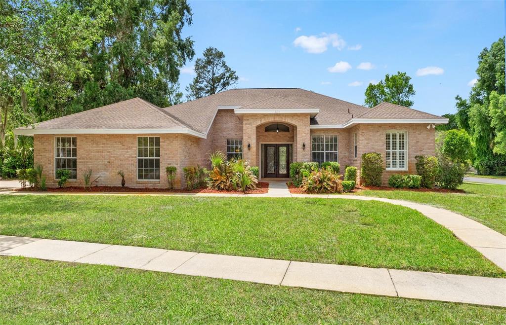 A single-story brick house with a hip roof and a central arched entryway — 6153 NEW OSPREY POINT, WEEKI WACHEE, FL